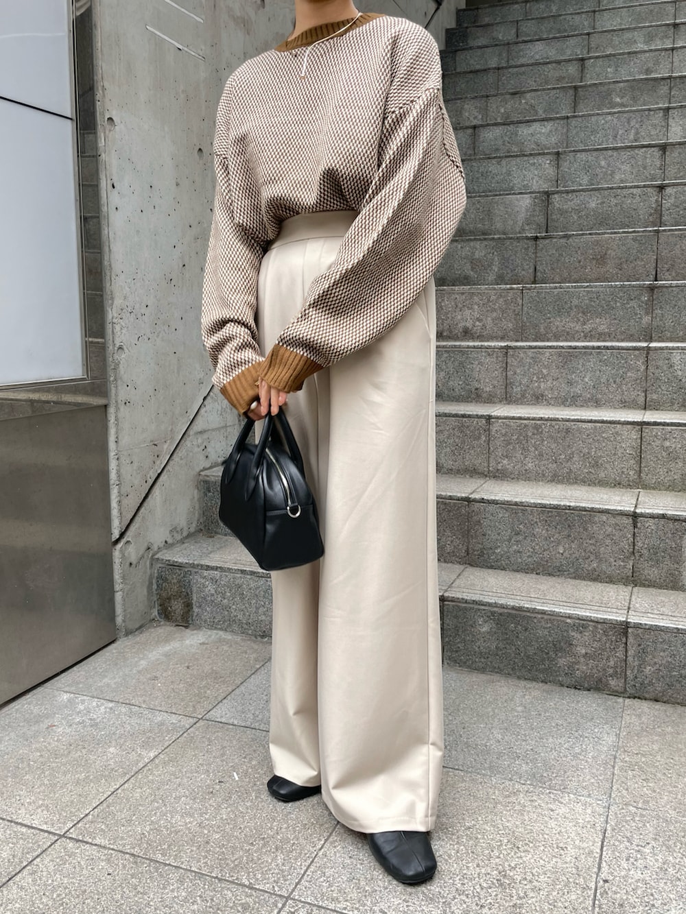 ブラウン系のニット/セーター、ホワイト系のパンツ、ゴールド系のネックレスを着用したレディースの秋コーディネートの3枚目の写真