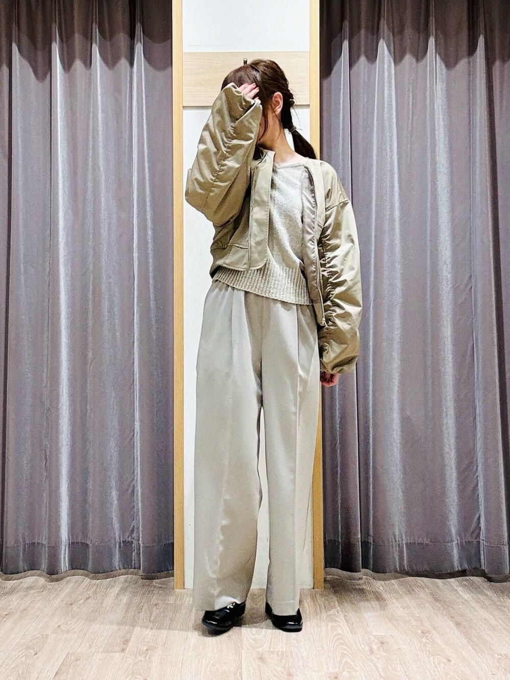 グリーン系のニット/セーター、ベージュ系のその他パンツ、ブラック系のハンドバッグを着用したレディースの春コーディネートの5枚目の写真