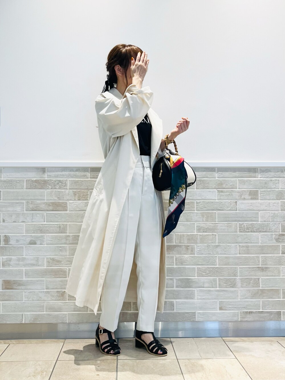 ブラック系のハンドバッグ、ブラック系のTシャツ/カットソー、ベージュ系のその他アウターを着用したレディースの春コーディネートの5枚目の写真