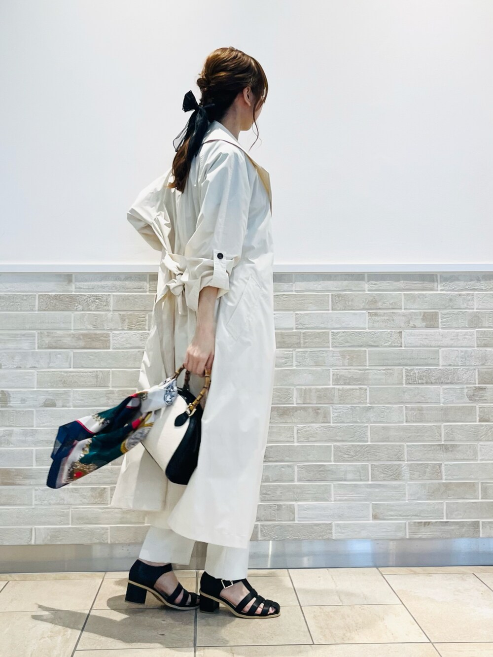 ブラック系のハンドバッグ、ブラック系のTシャツ/カットソー、ベージュ系のその他アウターを着用したレディースの春コーディネートの4枚目の写真