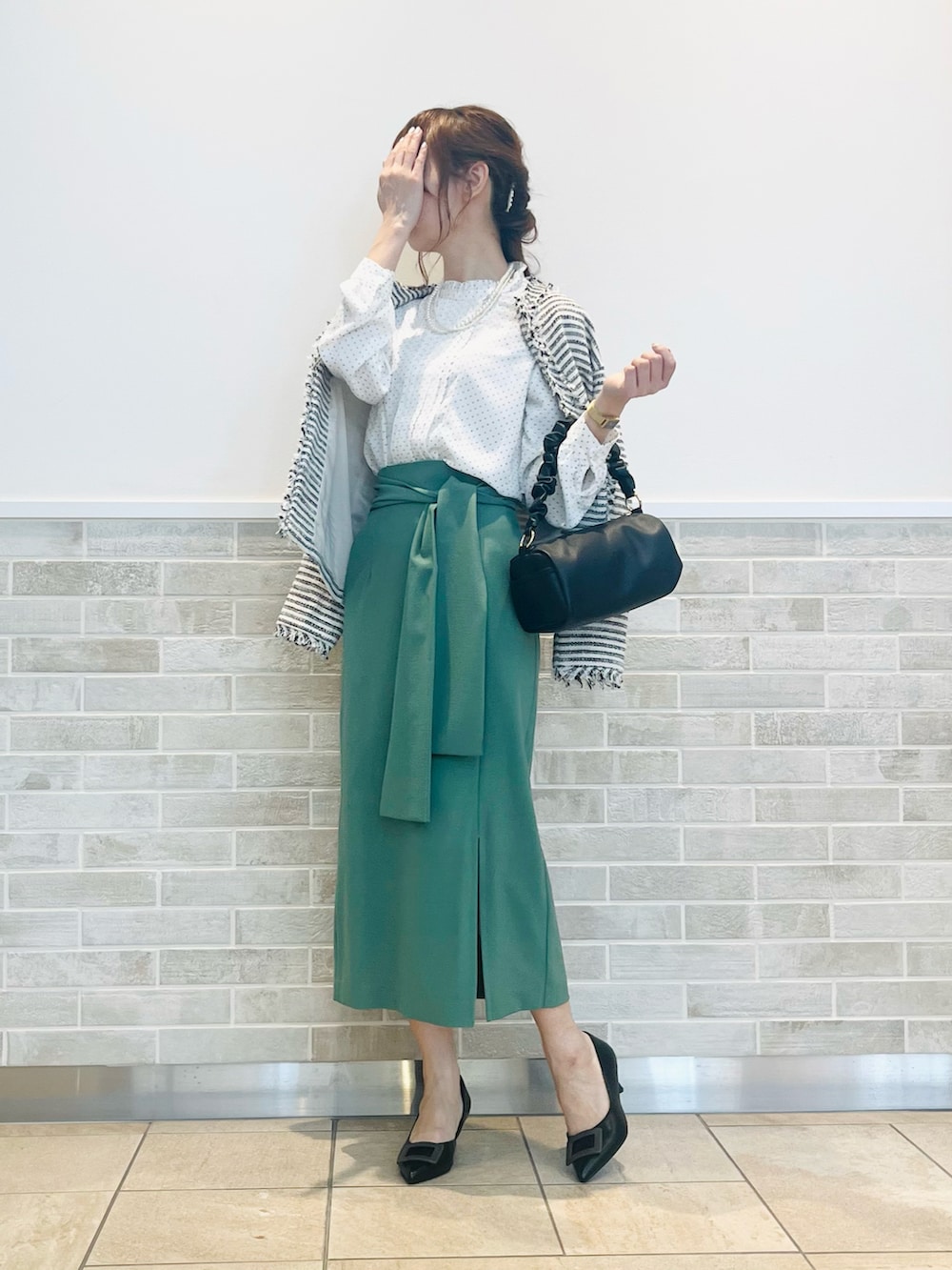 ホワイト系のシャツ/ブラウス、ブラック系のノーカラージャケット、ブラック系のハンドバッグを着用したレディースの春コーディネートの3枚目の写真