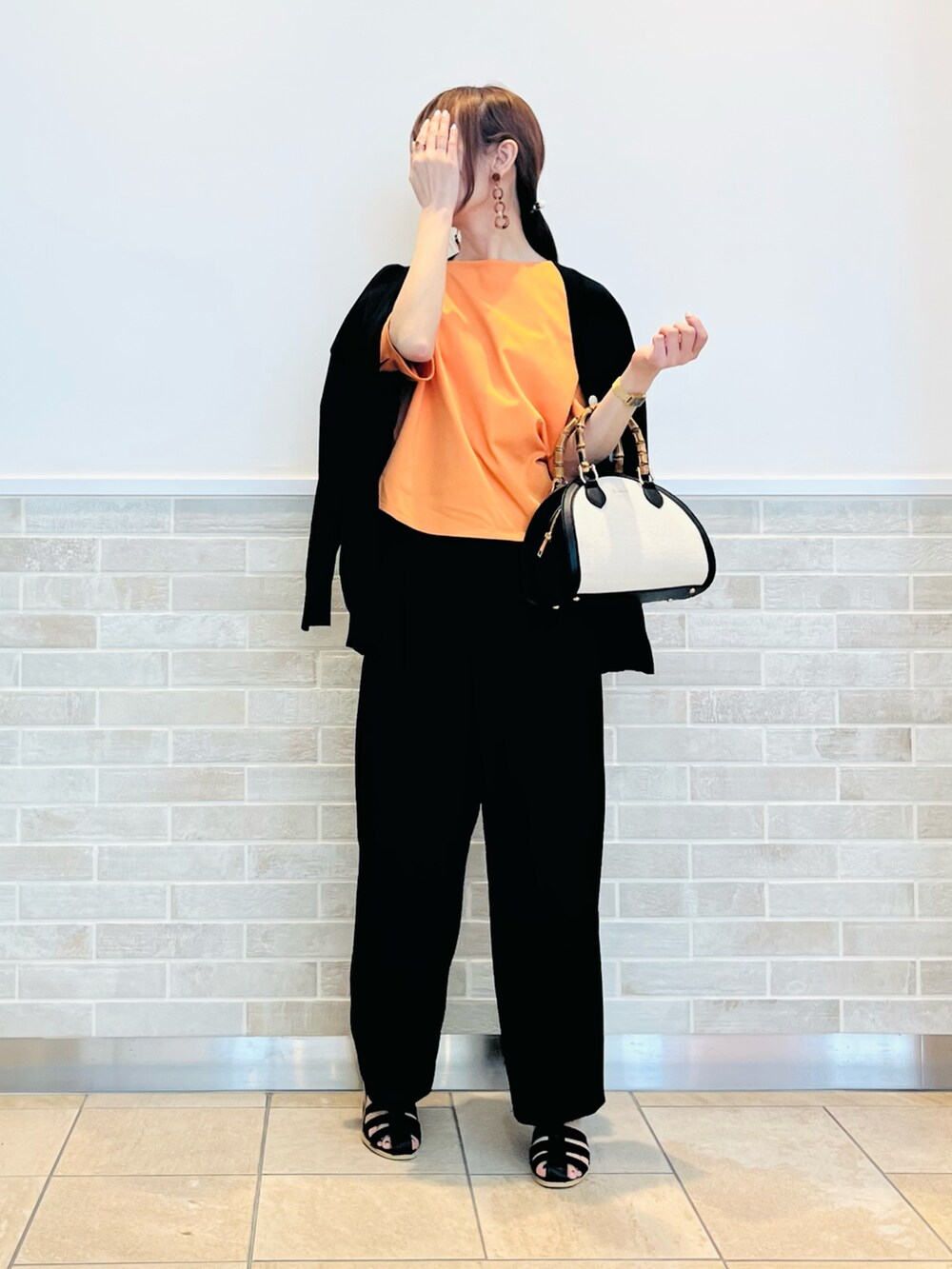 ブラック系のその他パンツ、ブラック系のサンダル、ブラック系のハンドバッグを着用したレディースの春コーディネートの3枚目の写真