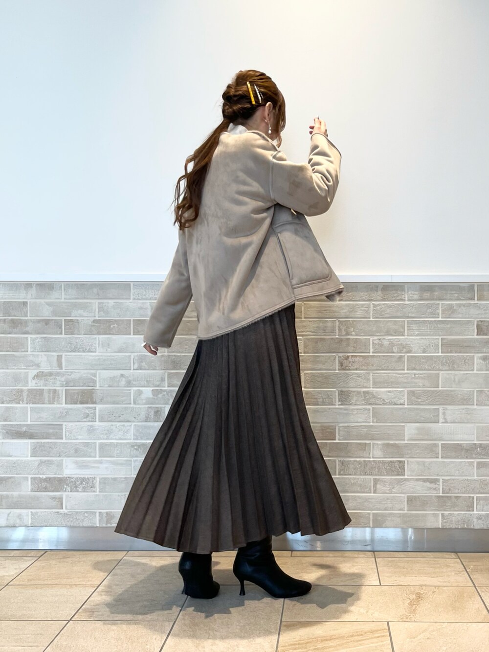 ブラウン系のスカート、ホワイト系のシャツ/ブラウス、ブラウン系のブルゾンを着用したレディースの冬コーディネートの2枚目の写真