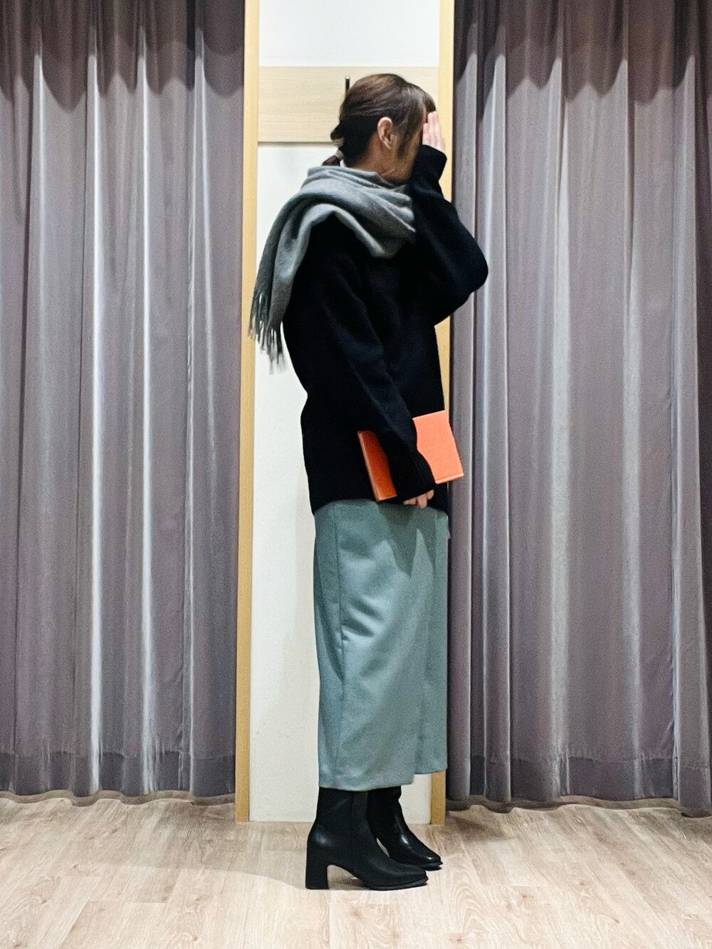 グリーン系のスカート、ブラック系のブーツ、グレー系のストール/ショールを着用したレディースの秋コーディネートの3枚目の写真