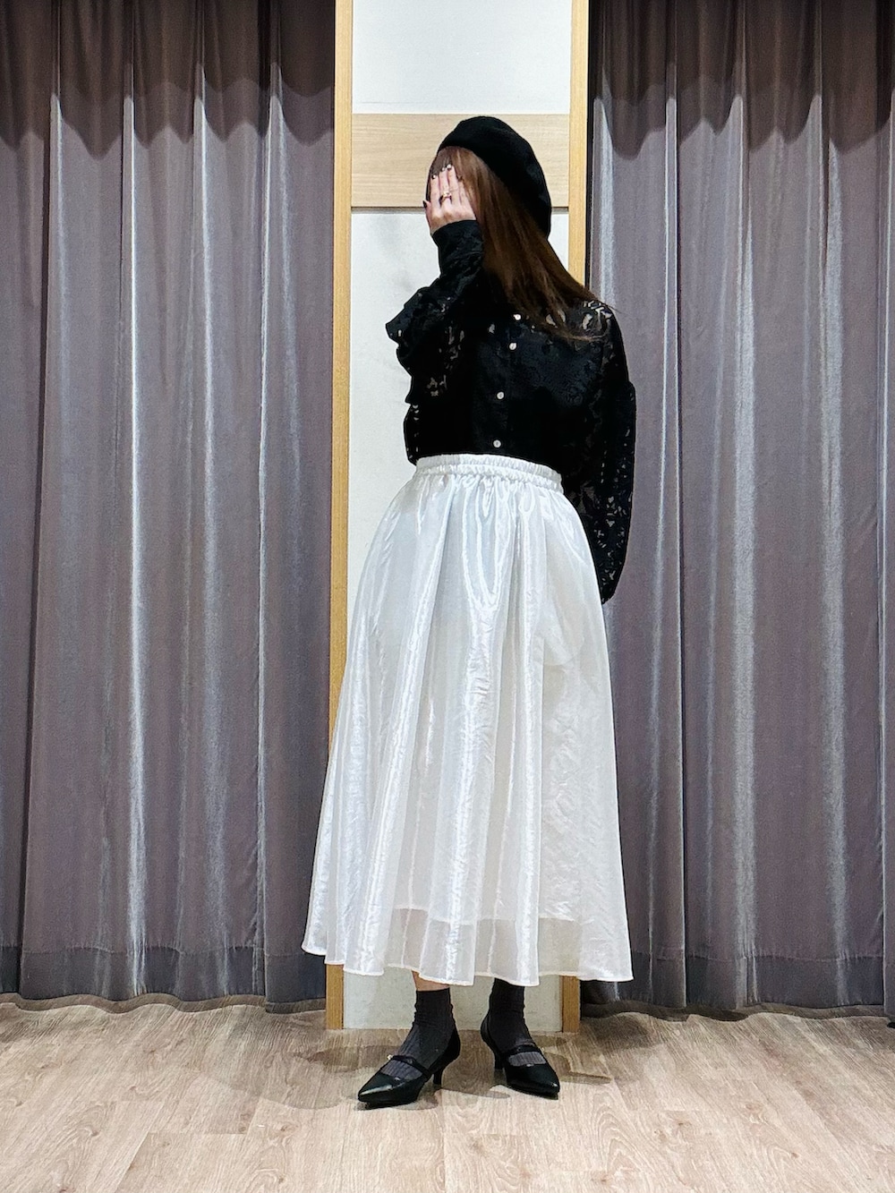 ホワイト系のスカート、ブラック系のシャツ/ブラウス、ブラック系のパンプスを着用したレディースの春コーディネートの2枚目の写真