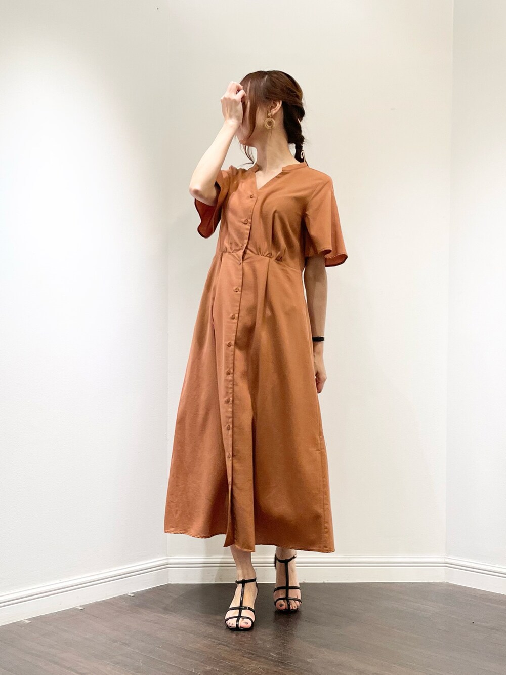 ブラウン系のワンピース、ブラック系のサンダル、ベージュ系のイヤリングを着用したレディースの春コーディネートの3枚目の写真