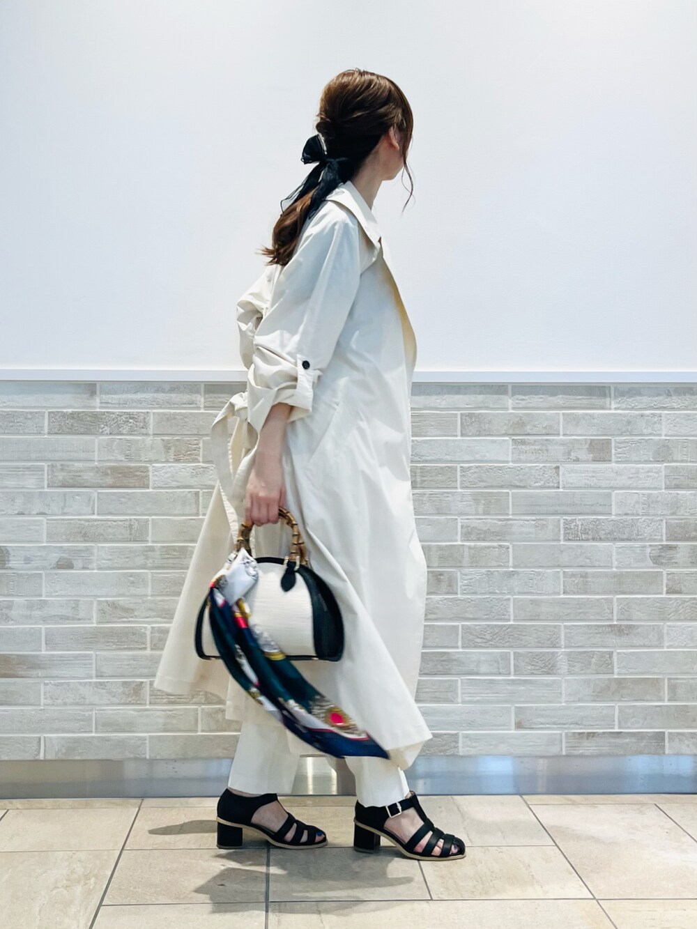 ブラック系のハンドバッグ、ブラック系のTシャツ/カットソー、ベージュ系のその他アウターを着用したレディースの春コーディネートの3枚目の写真