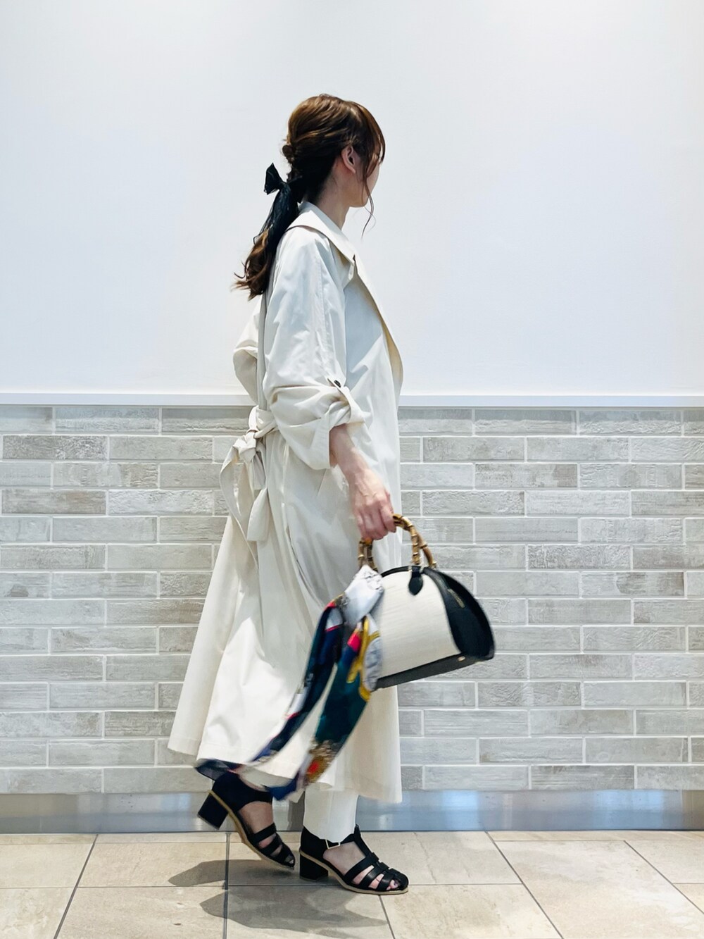 ブラック系のハンドバッグ、ブラック系のTシャツ/カットソー、ベージュ系のその他アウターを着用したレディースの春コーディネートの2枚目の写真