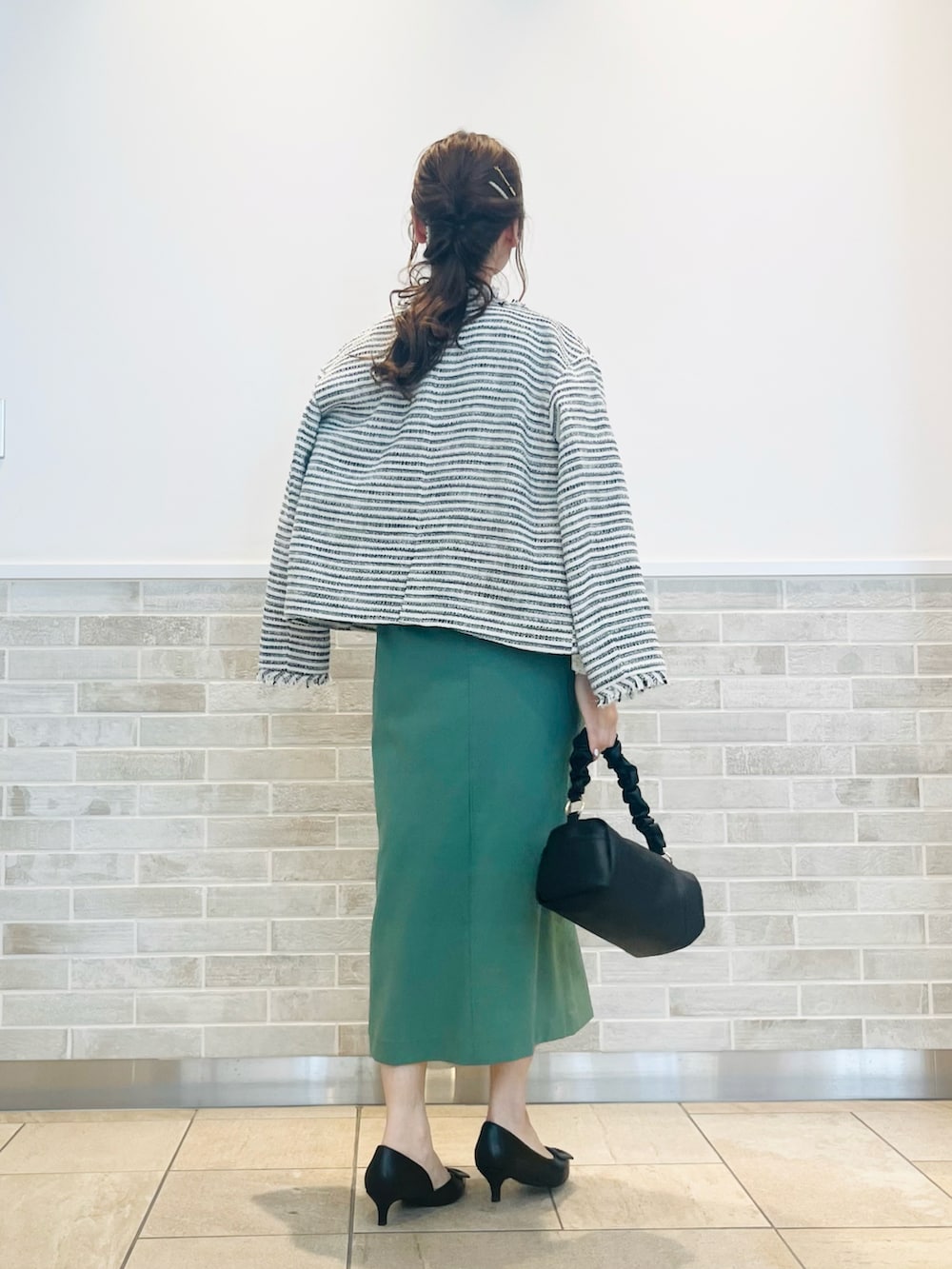 ホワイト系のシャツ/ブラウス、ブラック系のノーカラージャケット、ブラック系のハンドバッグを着用したレディースの春コーディネートの4枚目の写真