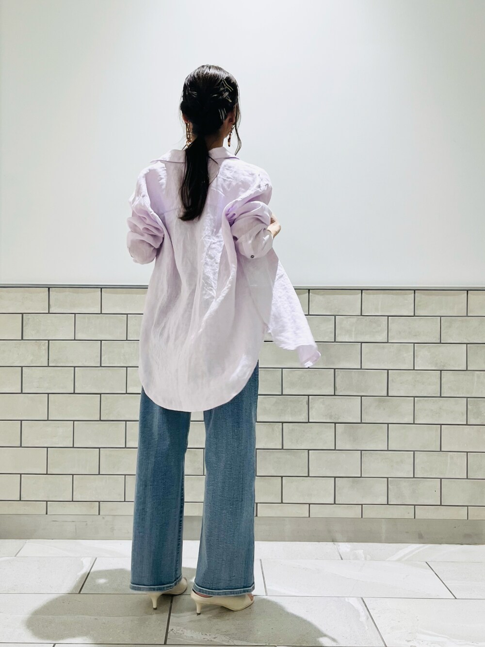 ブルー系のデニムパンツ、ホワイト系のサンダル、ピンク系のシャツ/ブラウスを着用したレディースの春コーディネートの2枚目の写真