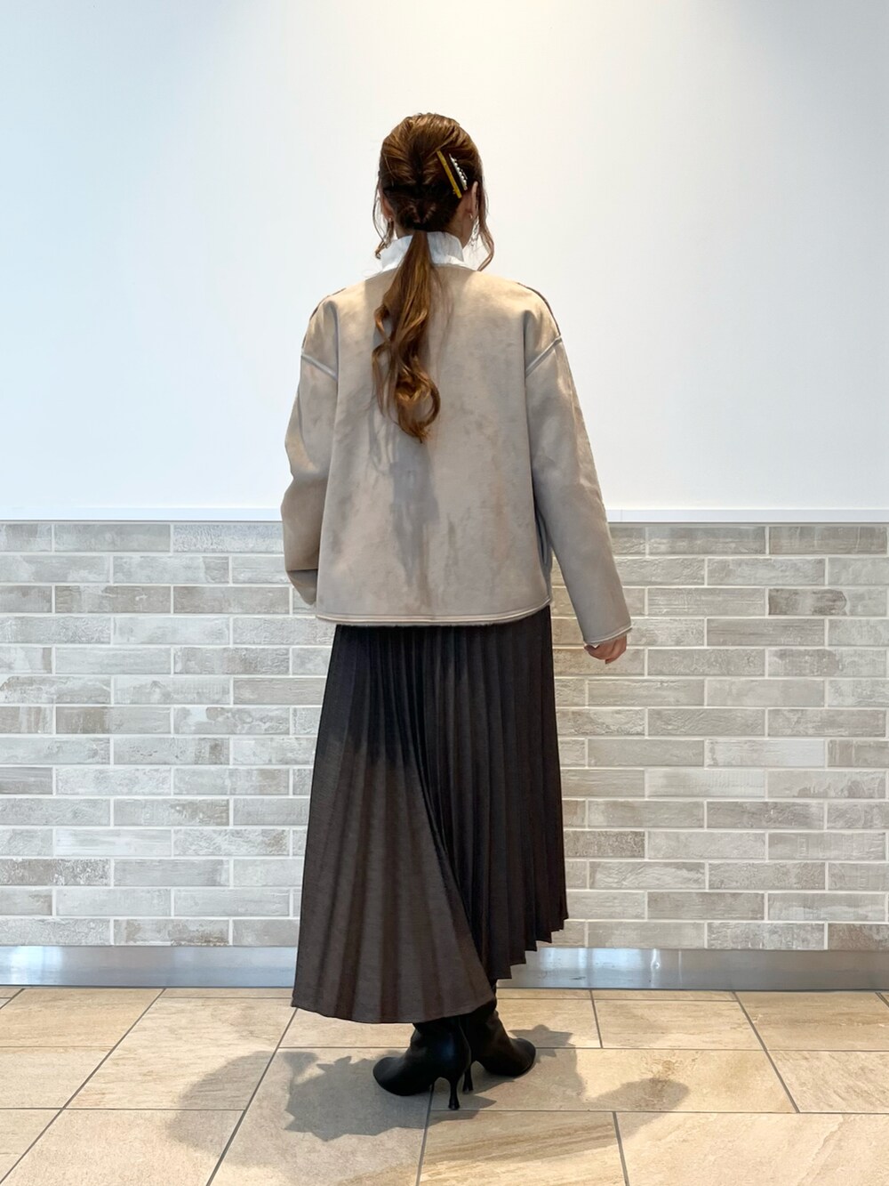 ブラウン系のスカート、ホワイト系のシャツ/ブラウス、ブラウン系のブルゾンを着用したレディースの冬コーディネートの4枚目の写真