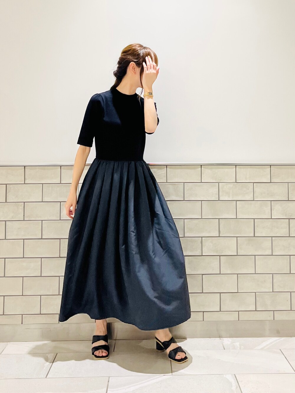 ブラック系のワンピース、ブラック系のサンダル、その他のスマホグッズを着用したレディースの夏コーディネートの5枚目の写真