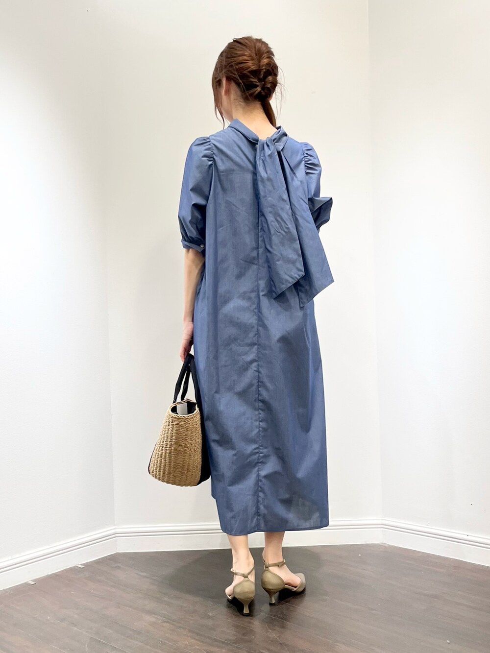 ブルー系のワンピース、ベージュ系のパンプス、イエロー系のハンドバッグを着用したレディースの春コーディネートの3枚目の写真