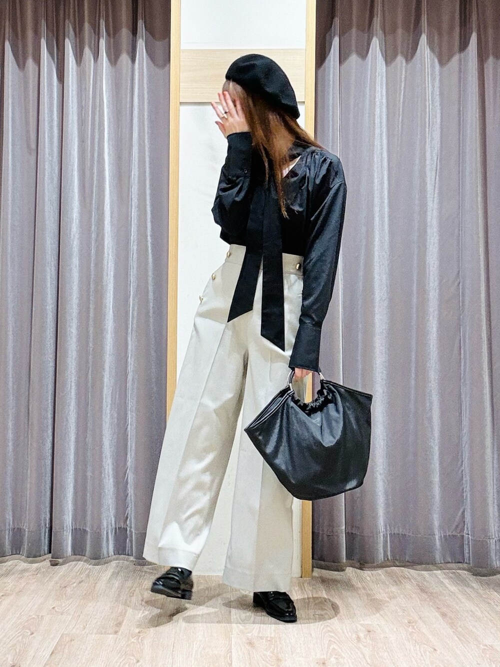 ブラック系のハンドバッグ、ブラック系のローファー、ベージュ系のその他パンツを着用したレディースの冬コーディネートの2枚目の写真