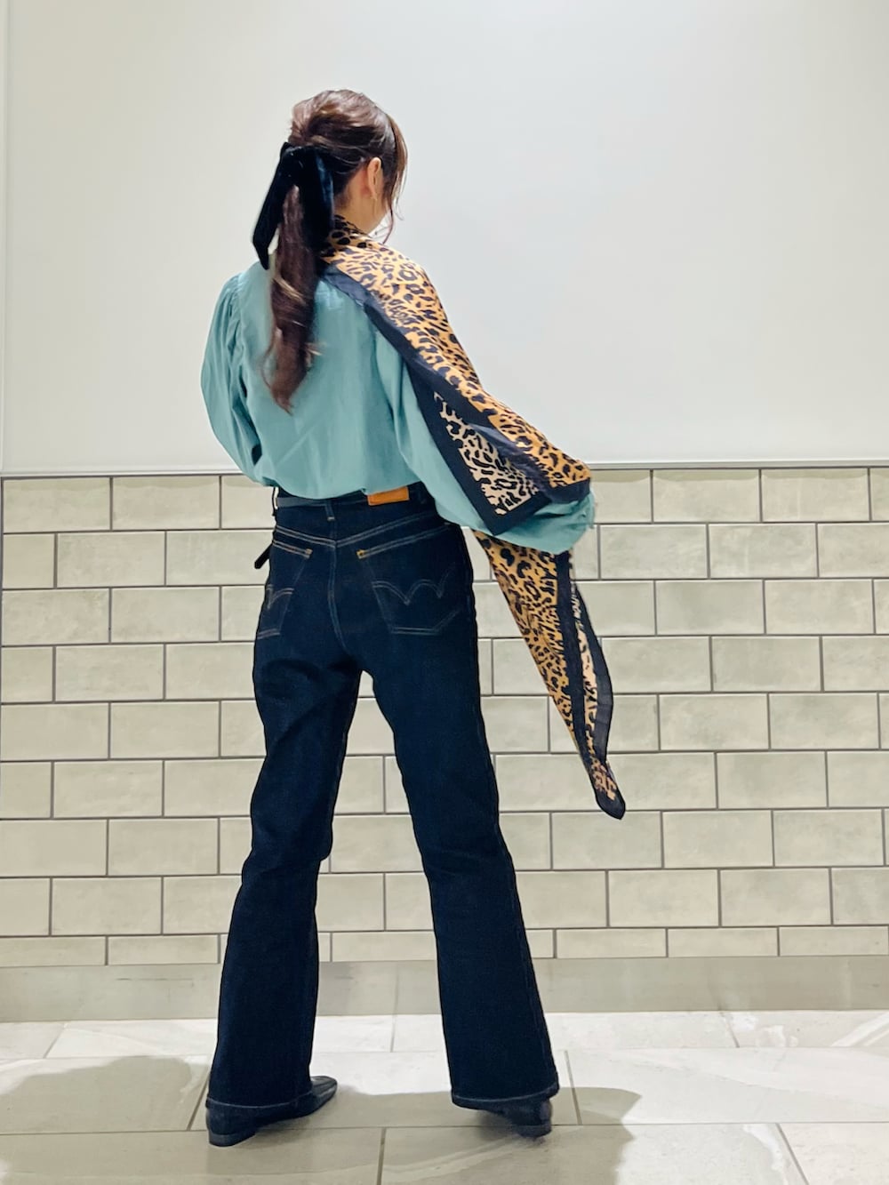 グリーン系のシャツ/ブラウス、ブラック系のローファー、ブラウン系のストール/ショールを着用したレディースの秋コーディネートの2枚目の写真