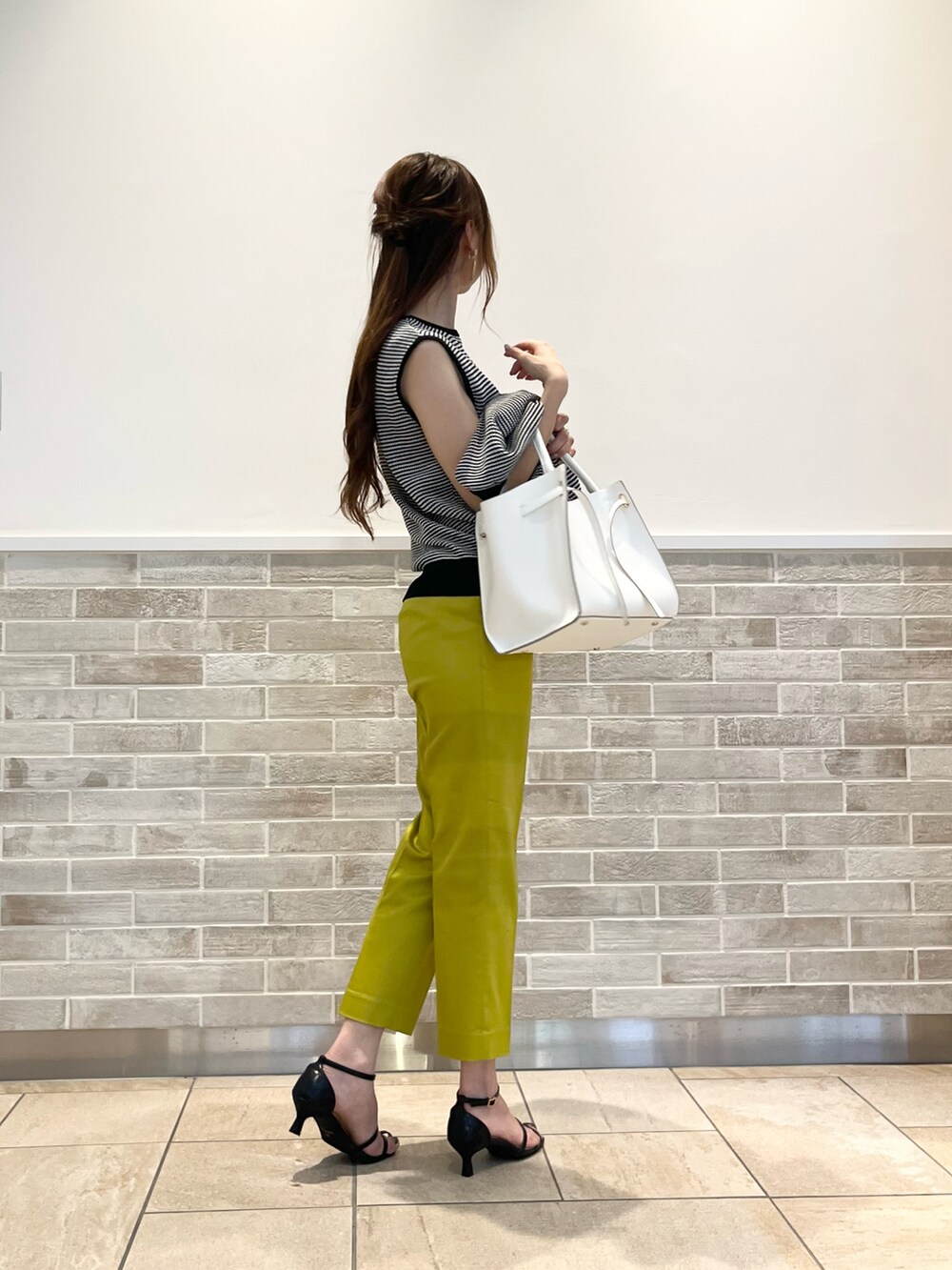 イエロー系のその他パンツ、ブラック系のサンダル、ホワイト系のバッグを着用したレディースの夏コーディネートの3枚目の写真