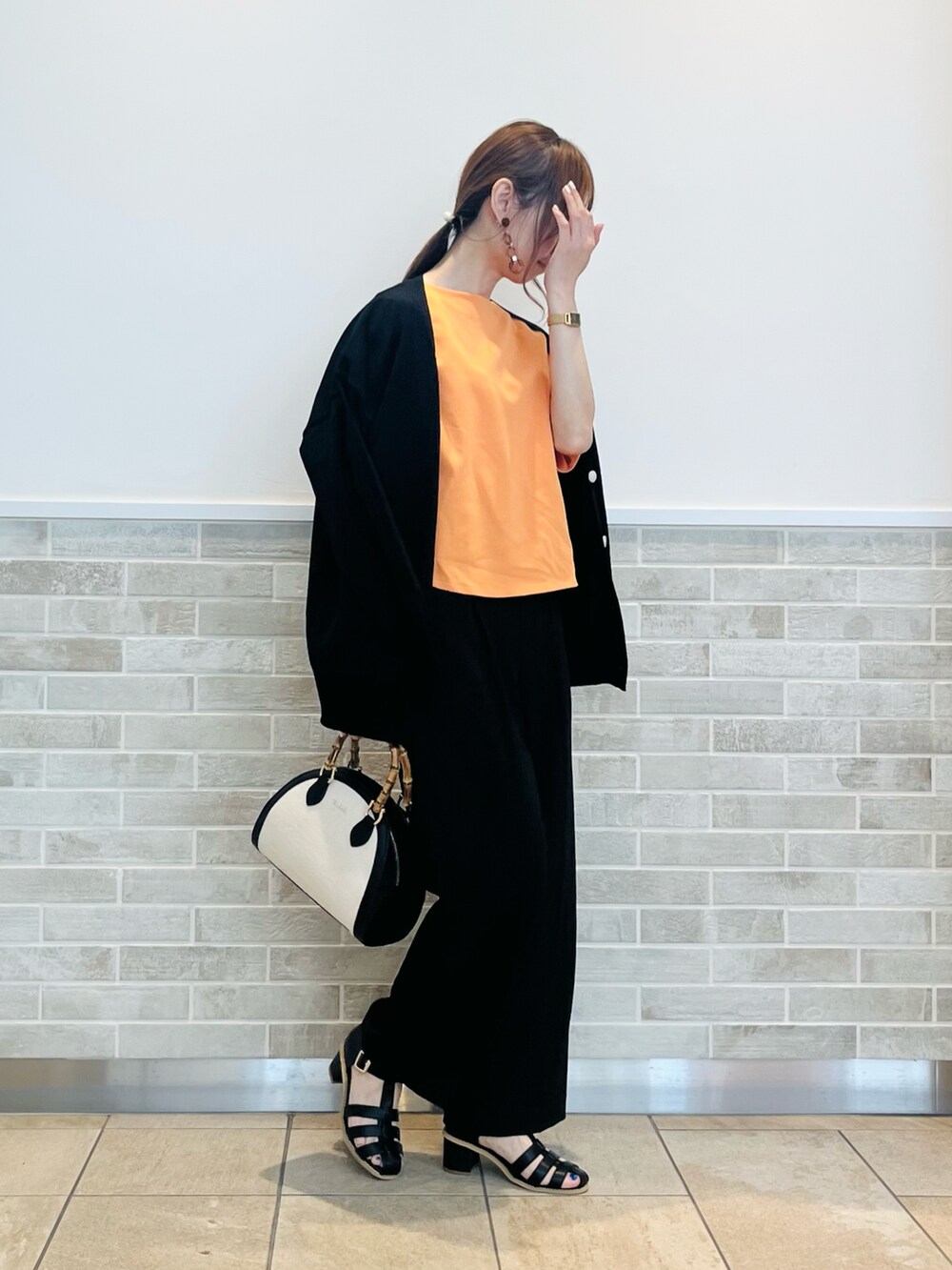 ブラック系のその他パンツ、ブラック系のサンダル、ブラック系のハンドバッグを着用したレディースの春コーディネートの5枚目の写真