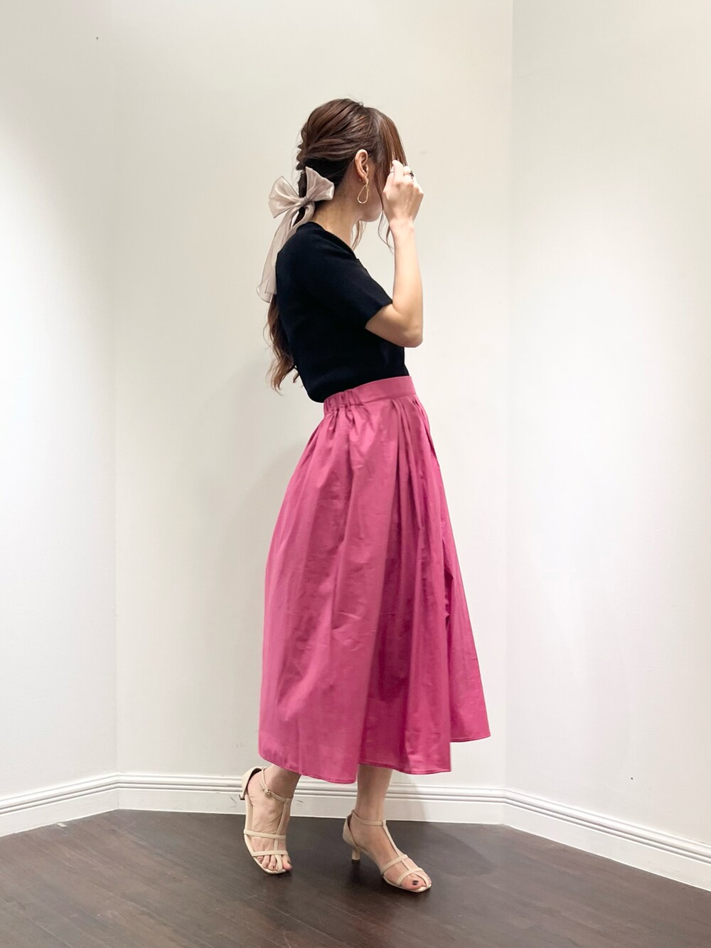 ブラック系のニット/セーター、ピンク系のスカート、ホワイト系のサンダルを着用したレディースの夏コーディネートの2枚目の写真