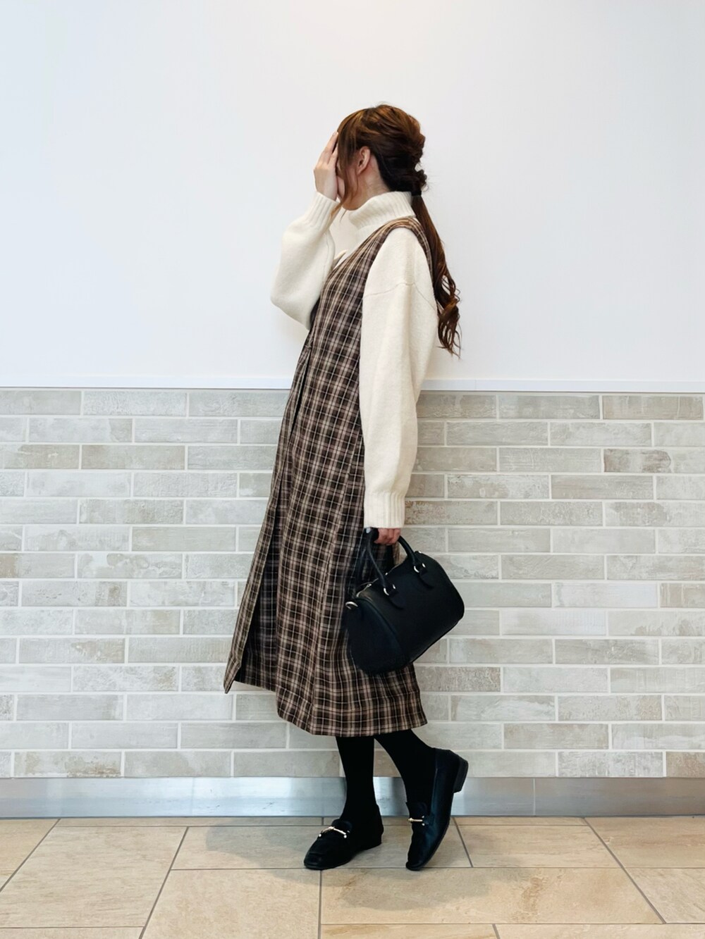ブラウン系のワンピース、ホワイト系のニット/セーター、ブラック系のドレスシューズを着用したレディースの秋コーディネートの3枚目の写真