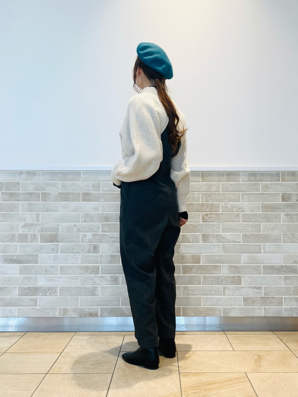 ホワイト系のニット/セーター、ブラック系のTシャツ/カットソー、グレー系のパンツを着用したレディースの冬コーディネートの3枚目の写真