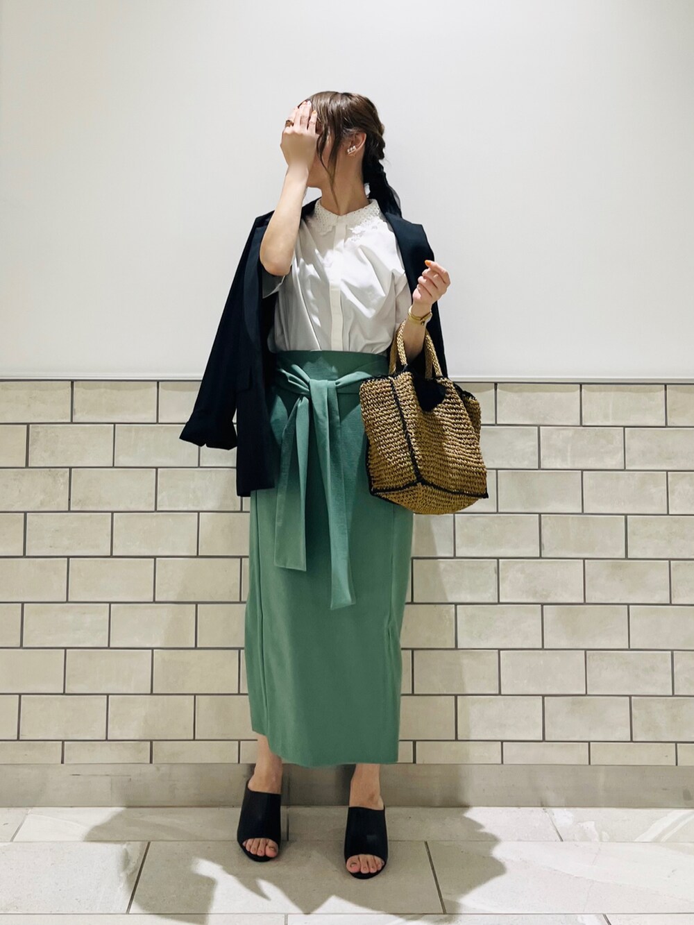 ブラック系のノーカラージャケット、ホワイト系のシャツ/ブラウス、グリーン系のスカートを着用したレディースの春コーディネートの3枚目の写真