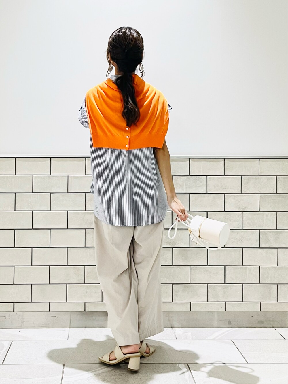 ホワイト系のサンダル、ブルー系のシャツ/ブラウス、ホワイト系のハンドバッグを着用したレディースの夏コーディネートの4枚目の写真