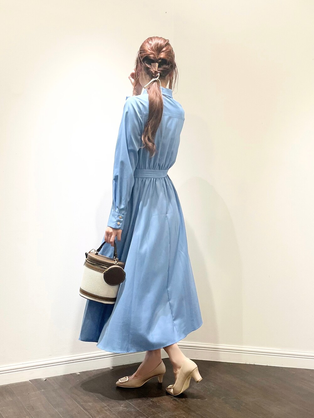 ブルー系のワンピース、ベージュ系のドレスシューズ、ブラウン系のショルダーバッグを着用したレディースの春コーディネートの3枚目の写真