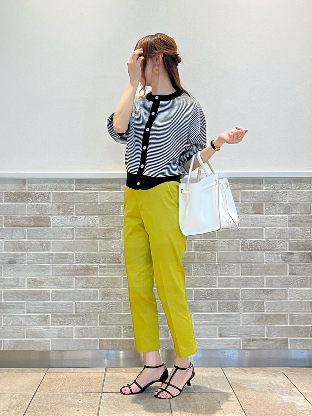 イエロー系のその他パンツ、ブラック系のサンダル、ホワイト系のバッグを着用したレディースの夏コーディネートの2枚目の写真