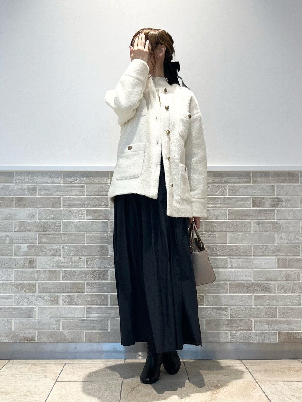 ホワイト系のその他アウター、ホワイト系のニット/セーター、ブラック系のスカートを着用したレディースの秋コーディネートの4枚目の写真