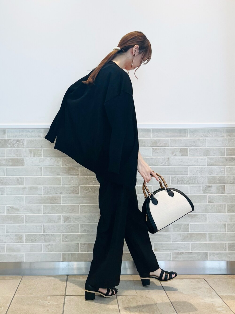 ブラック系のその他パンツ、ブラック系のサンダル、ブラック系のハンドバッグを着用したレディースの春コーディネートの4枚目の写真