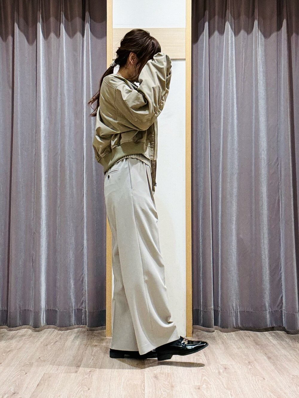 グリーン系のニット/セーター、ベージュ系のその他パンツ、ブラック系のハンドバッグを着用したレディースの春コーディネートの3枚目の写真