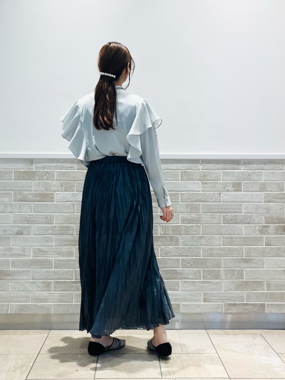 グレー系のスカート、グリーン系のシャツ/ブラウス、その他のスマホグッズを着用したレディースの春コーディネートの2枚目の写真