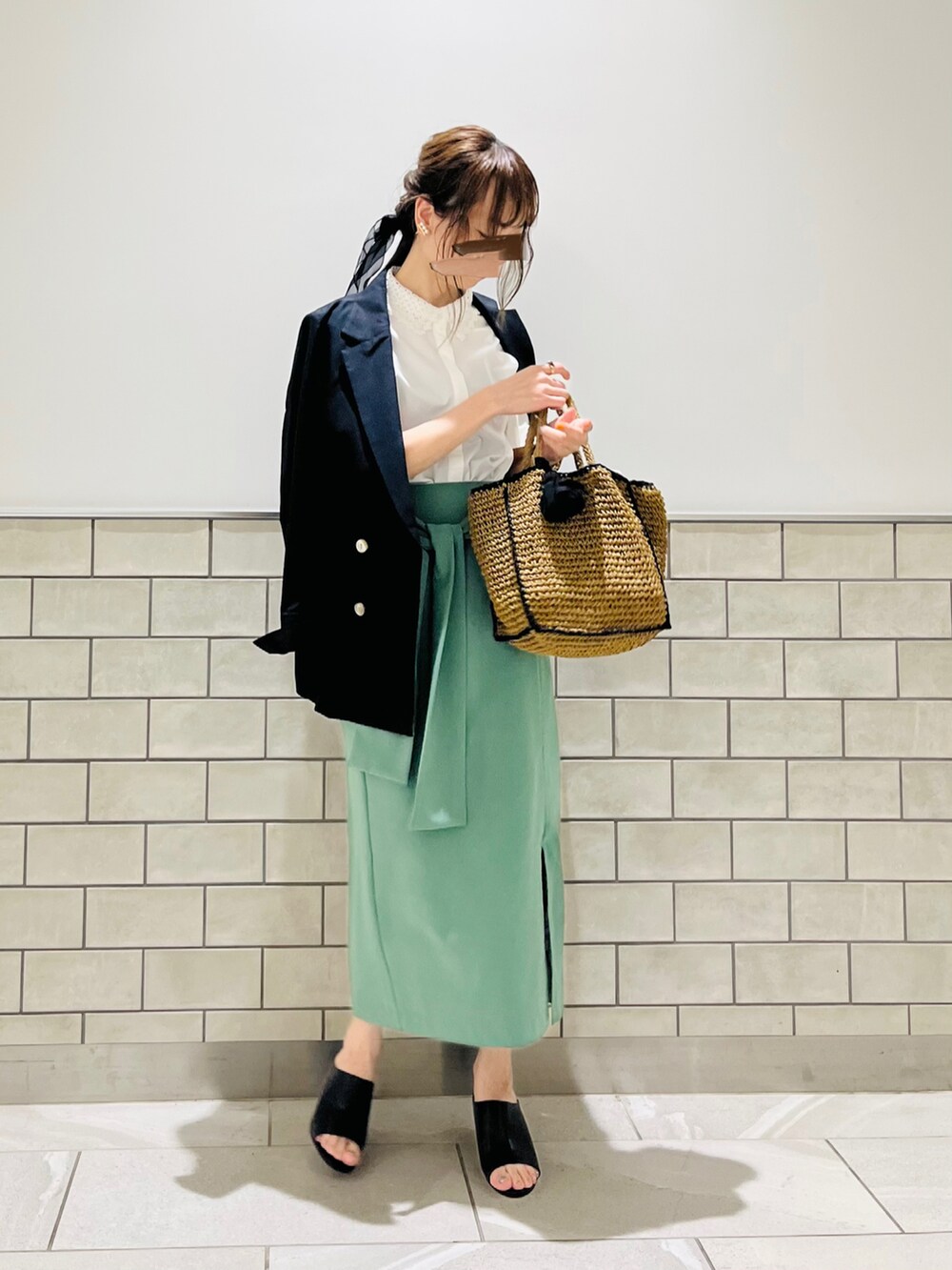 ブラック系のノーカラージャケット、ホワイト系のシャツ/ブラウス、グリーン系のスカートを着用したレディースの春コーディネートの2枚目の写真