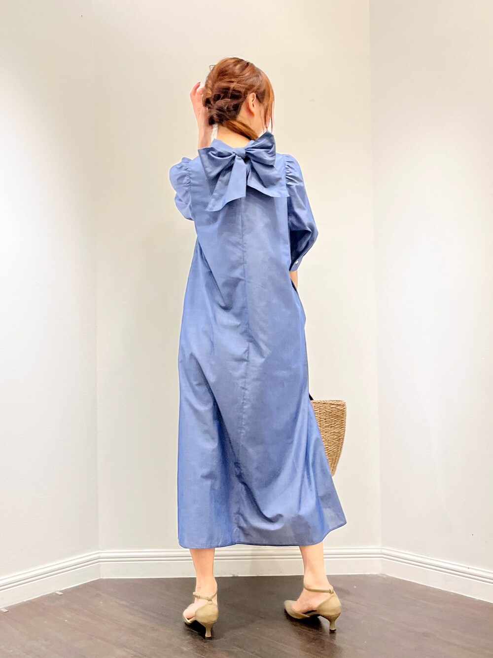 ブルー系のワンピース、ベージュ系のパンプス、イエロー系のハンドバッグを着用したレディースの春コーディネートの2枚目の写真