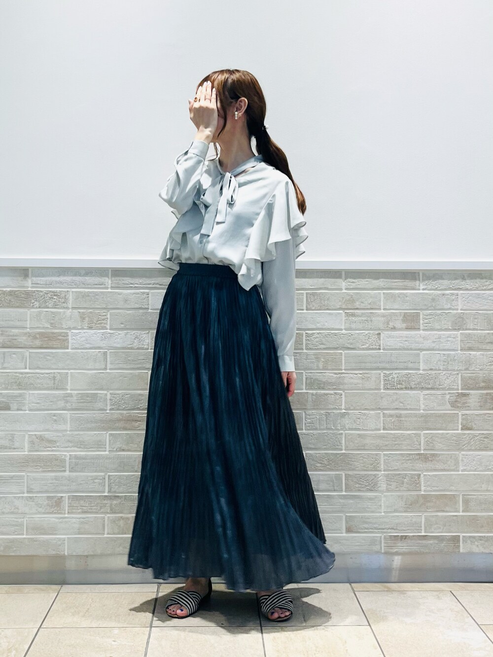 グレー系のスカート、グリーン系のシャツ/ブラウス、その他のスマホグッズを着用したレディースの春コーディネートの3枚目の写真