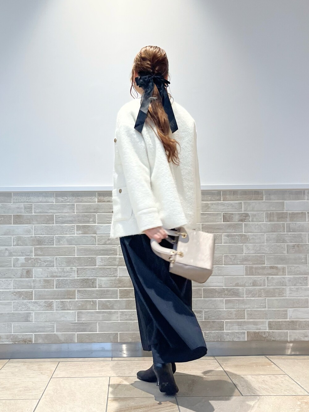 ホワイト系のその他アウター、ホワイト系のニット/セーター、ブラック系のスカートを着用したレディースの秋コーディネートの3枚目の写真