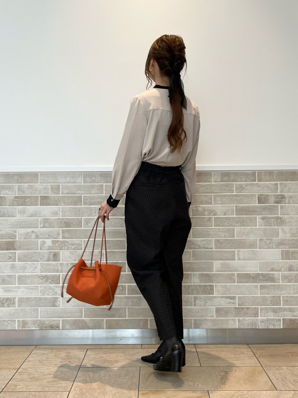 ブラック系のその他パンツ、ベージュ系のシャツ/ブラウス、オレンジ系のハンドバッグを着用したレディースの秋コーディネートの4枚目の写真