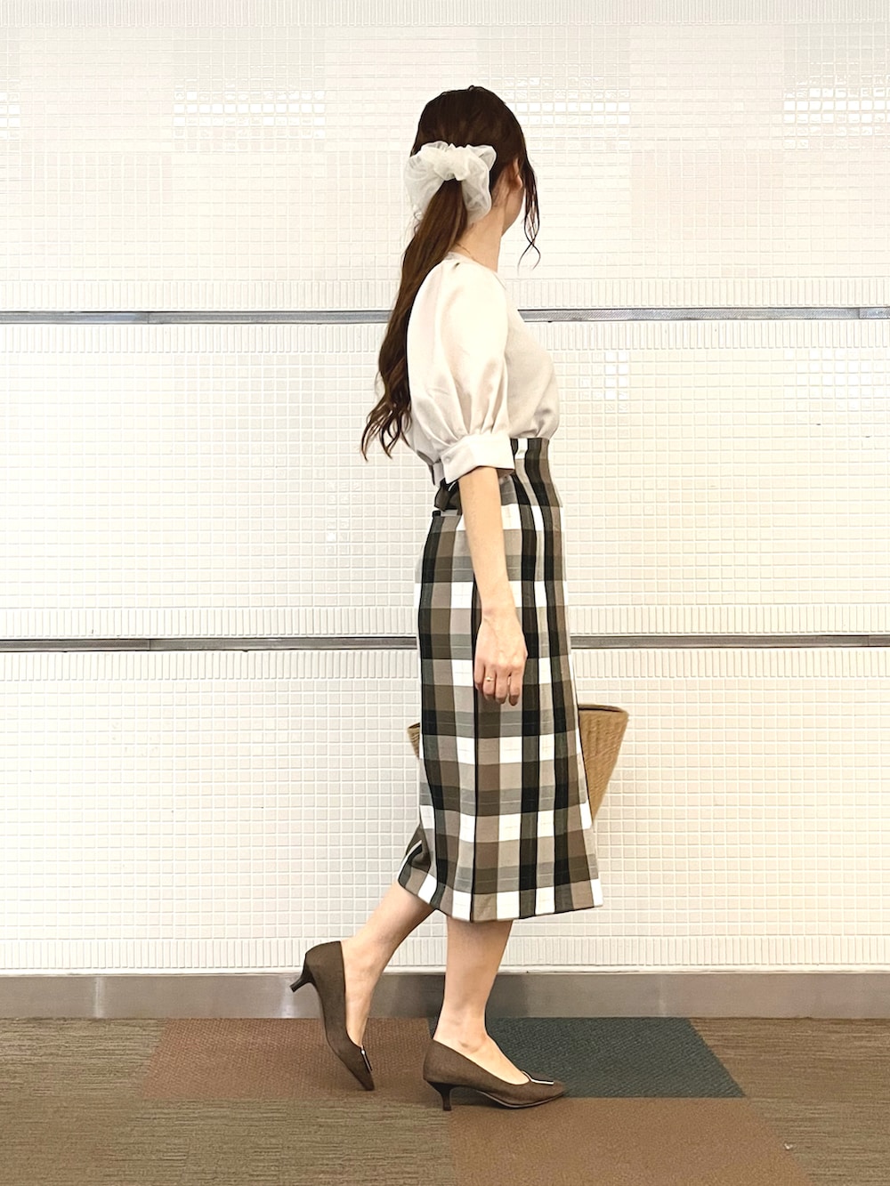 ベージュ系のシャツ/ブラウス、イエロー系のハンドバッグ、ブラウン系のパンプスを着用したレディースの春コーディネートの3枚目の写真