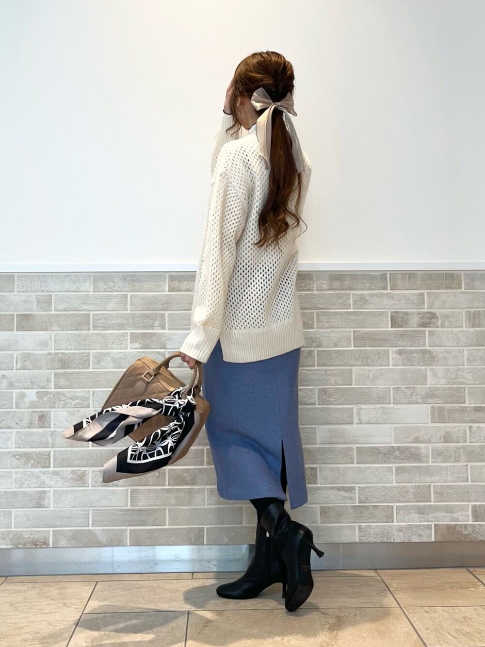 ベージュ系のハンドバッグ、ホワイト系のTシャツ/カットソー、ホワイト系のニット/セーターを着用したレディースの秋コーディネートの2枚目の写真
