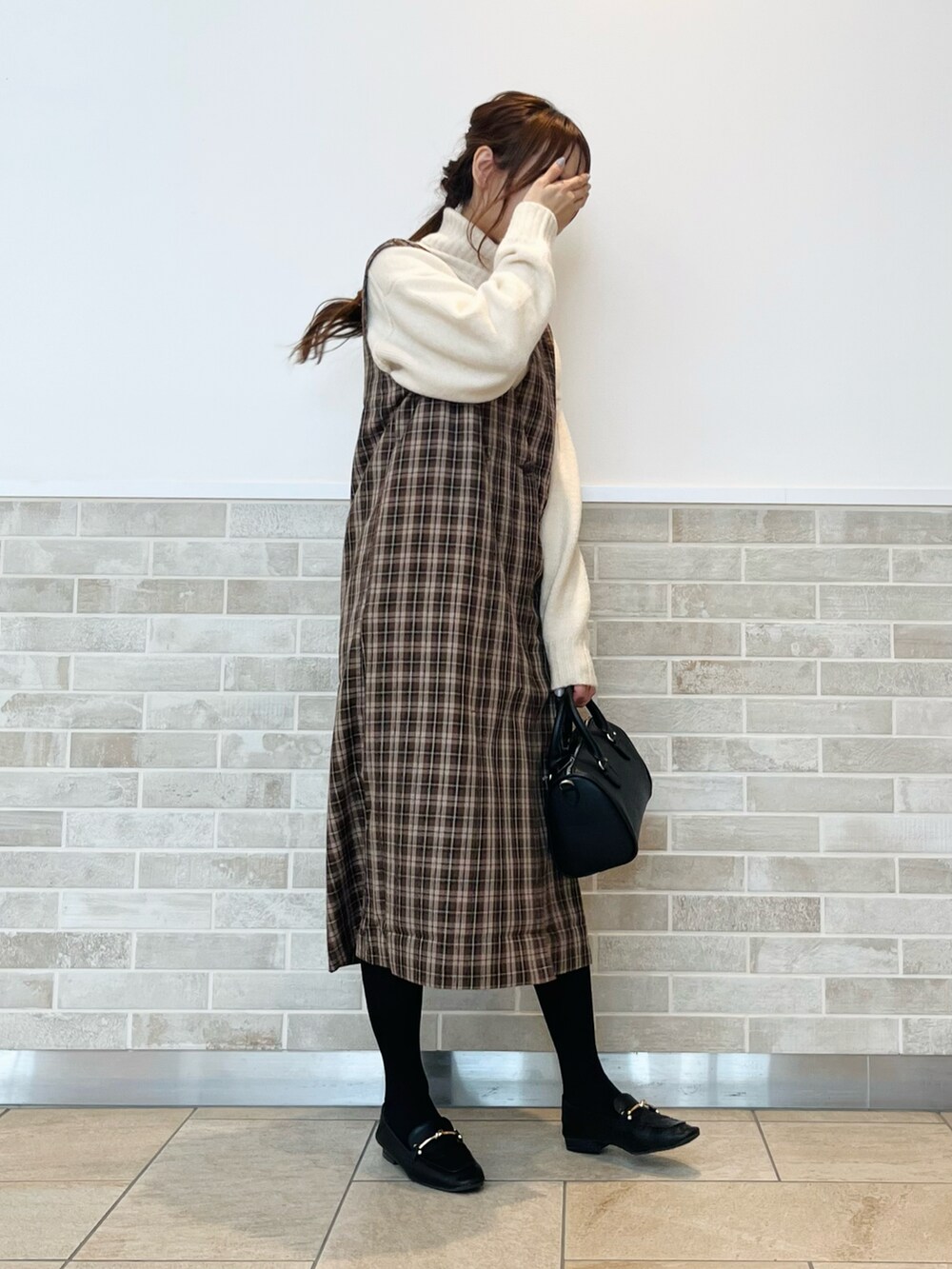 ブラウン系のワンピース、ホワイト系のニット/セーター、ブラック系のドレスシューズを着用したレディースの秋コーディネートの4枚目の写真