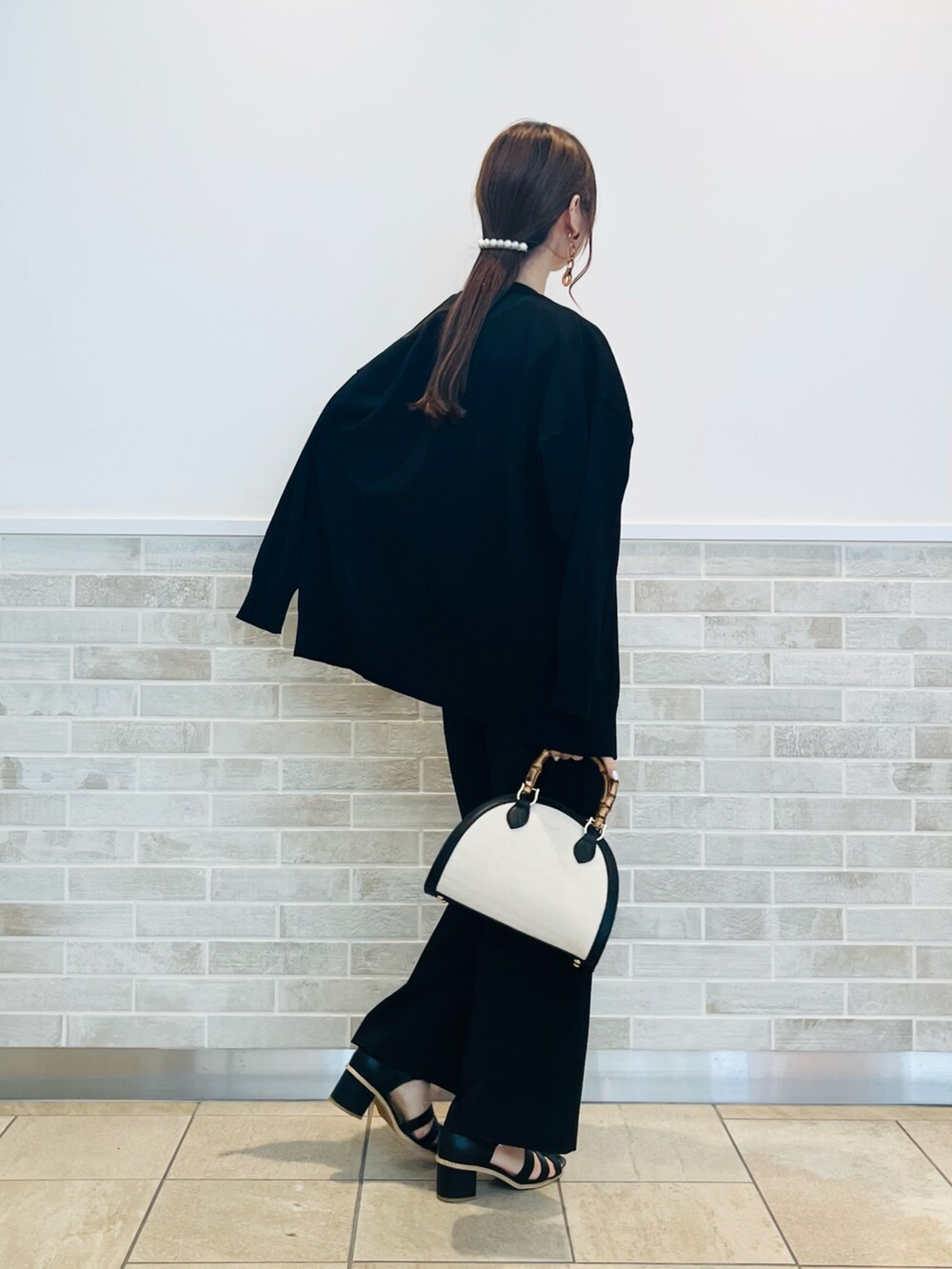 ブラック系のその他パンツ、ブラック系のサンダル、ブラック系のハンドバッグを着用したレディースの春コーディネートの2枚目の写真