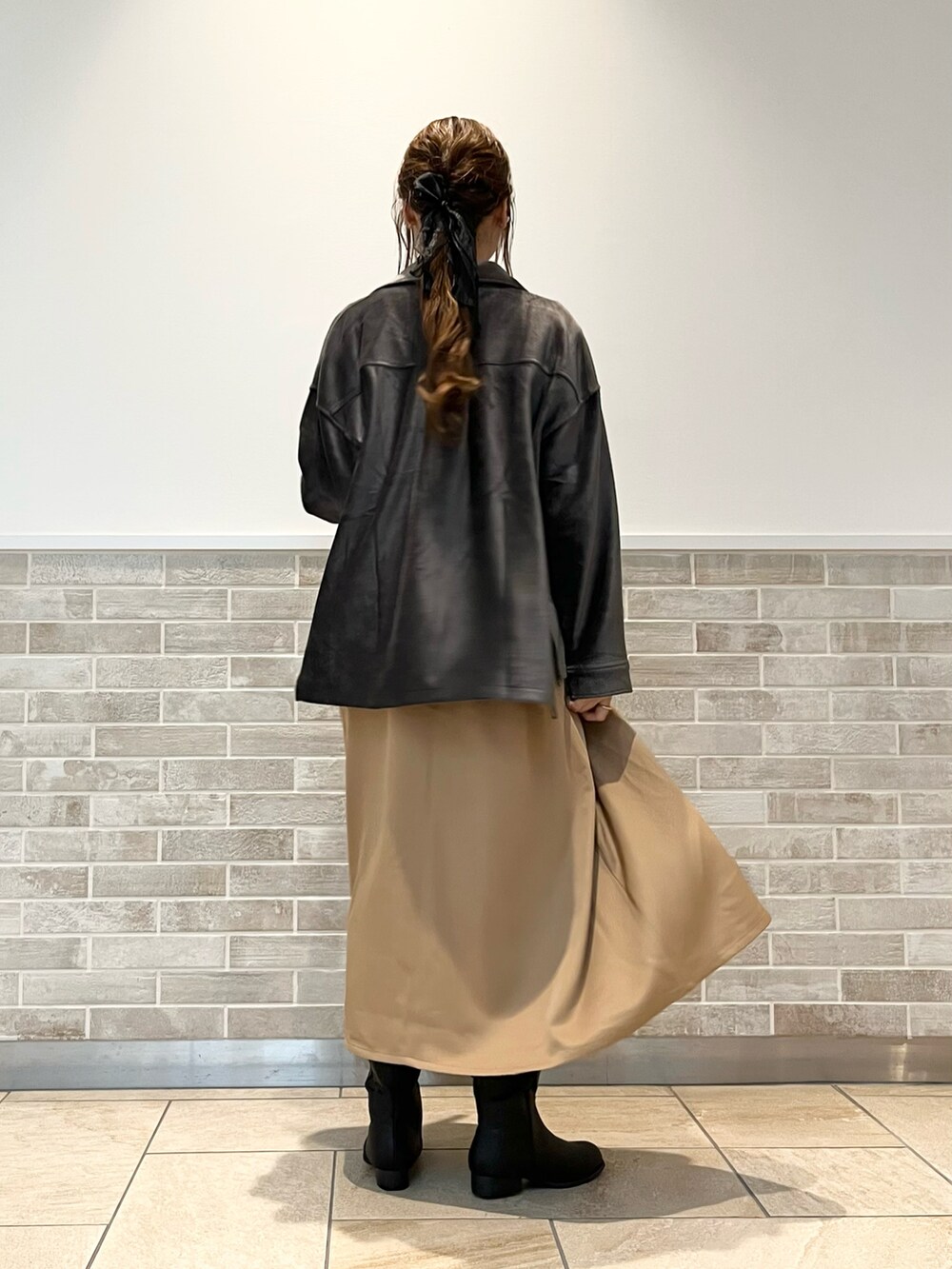 ベージュ系のワンピース、ブラウン系のニット/セーター、グレー系のノーカラージャケットを着用したレディースの秋コーディネートの2枚目の写真