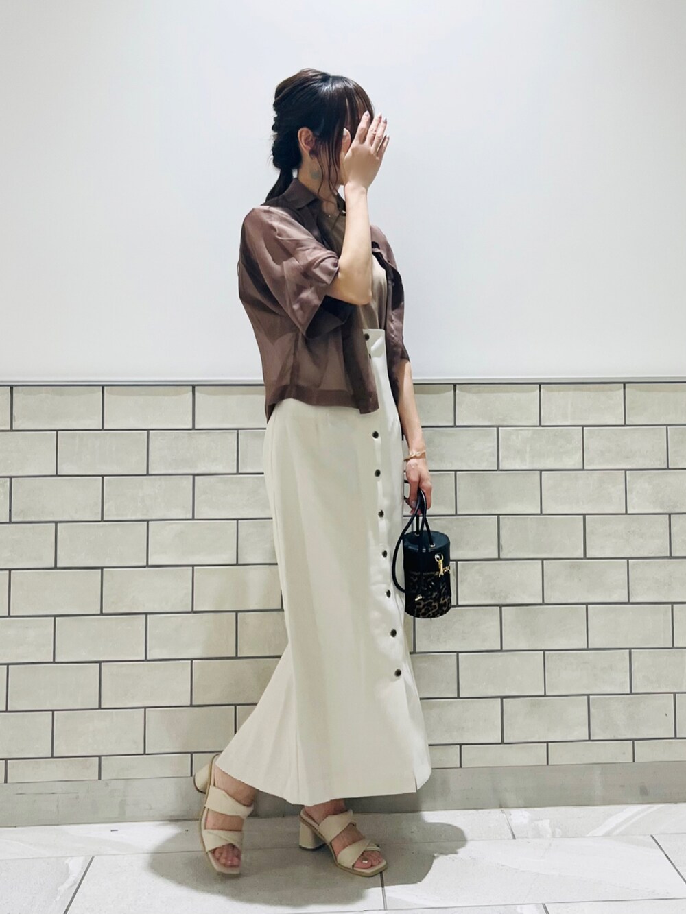 ホワイト系のサンダル、ブラウン系のシャツ/ブラウス、ブラウン系のTシャツ/カットソーを着用したレディースの夏コーディネートの2枚目の写真