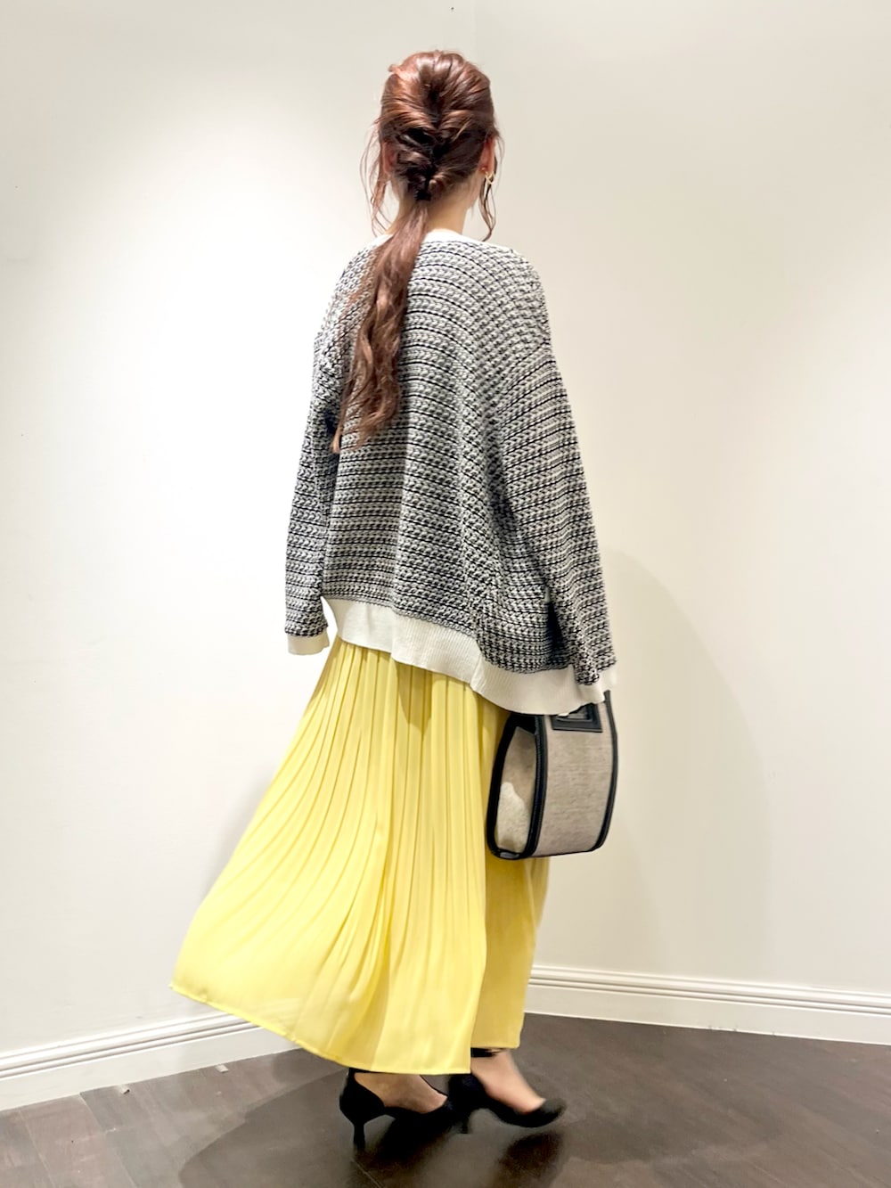 ブラック系のカーディガン/ボレロ、イエロー系のスカート、ブラック系のショルダーバッグを着用したレディースの春コーディネートの3枚目の写真