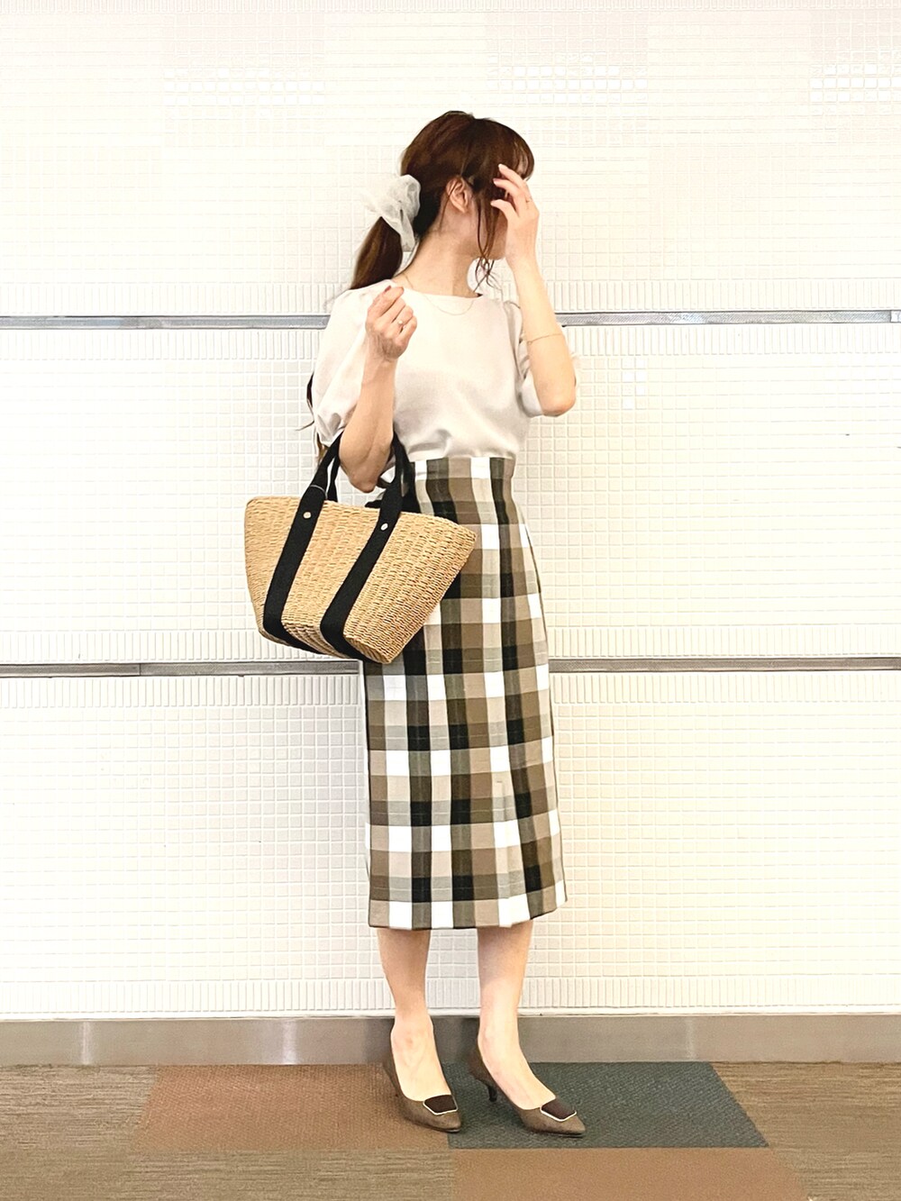 ベージュ系のシャツ/ブラウス、イエロー系のハンドバッグ、ブラウン系のパンプスを着用したレディースの春コーディネートの2枚目の写真