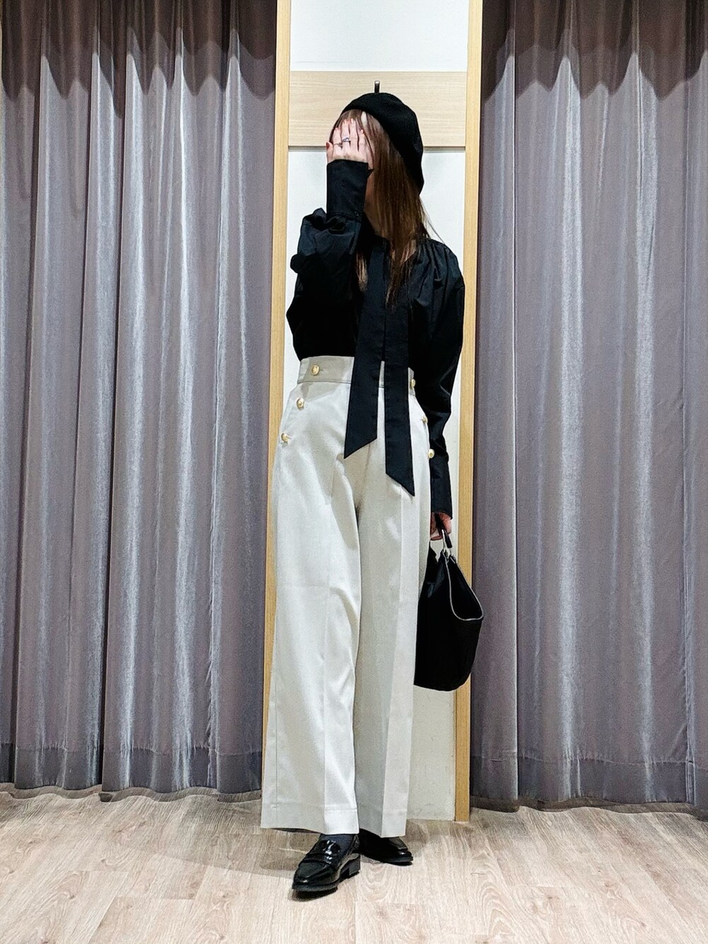 ブラック系のハンドバッグ、ブラック系のローファー、ベージュ系のその他パンツを着用したレディースの冬コーディネートの3枚目の写真