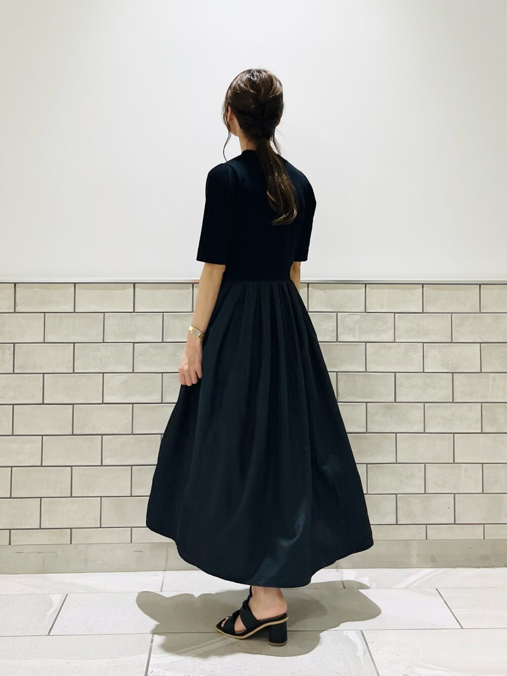 ブラック系のワンピース、ブラック系のサンダル、その他のスマホグッズを着用したレディースの夏コーディネートの2枚目の写真