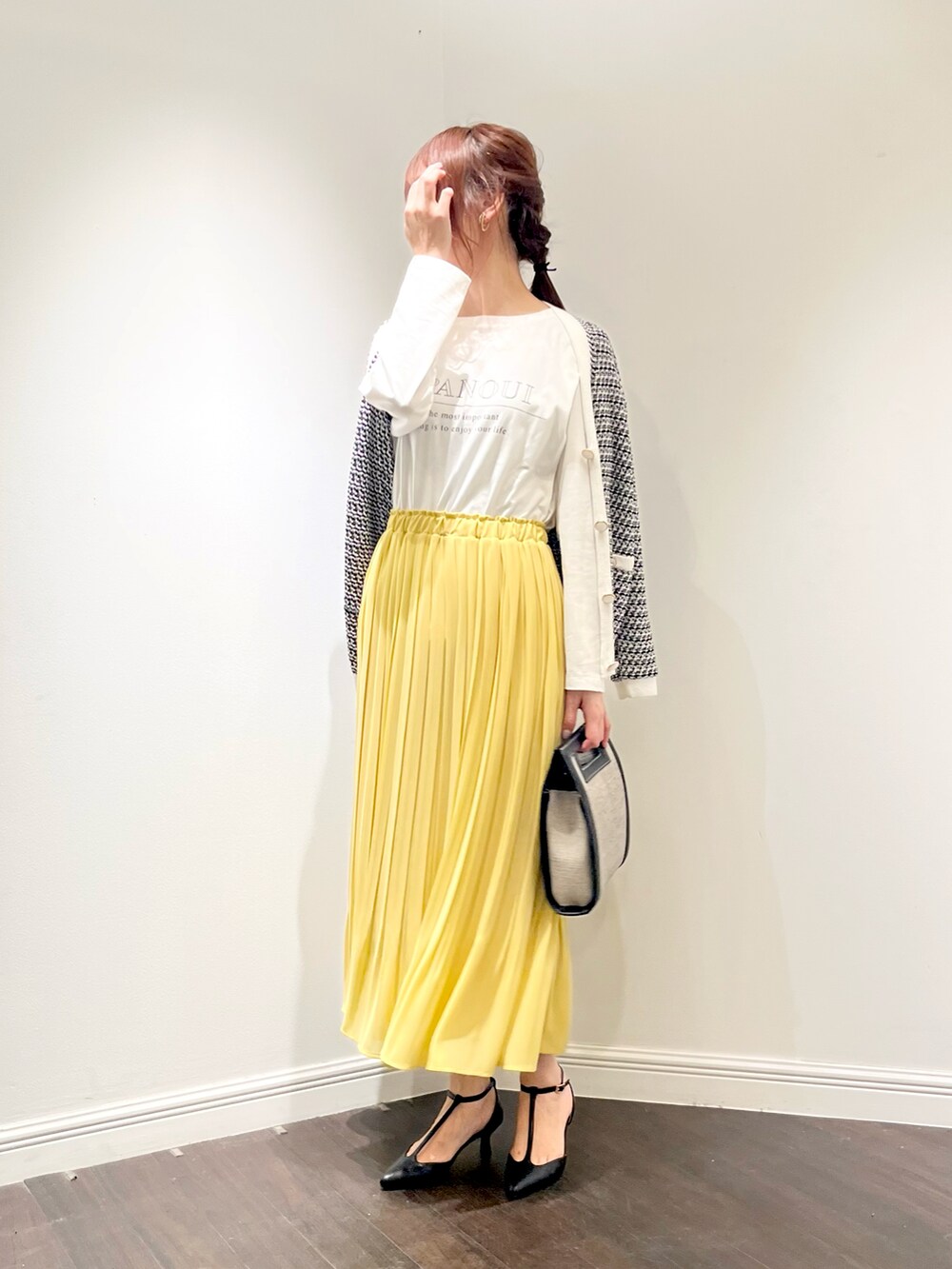 ブラック系のカーディガン/ボレロ、イエロー系のスカート、ブラック系のショルダーバッグを着用したレディースの春コーディネートの2枚目の写真