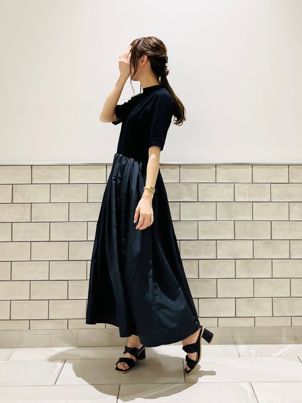 ブラック系のワンピース、ブラック系のサンダル、その他のスマホグッズを着用したレディースの夏コーディネートの4枚目の写真