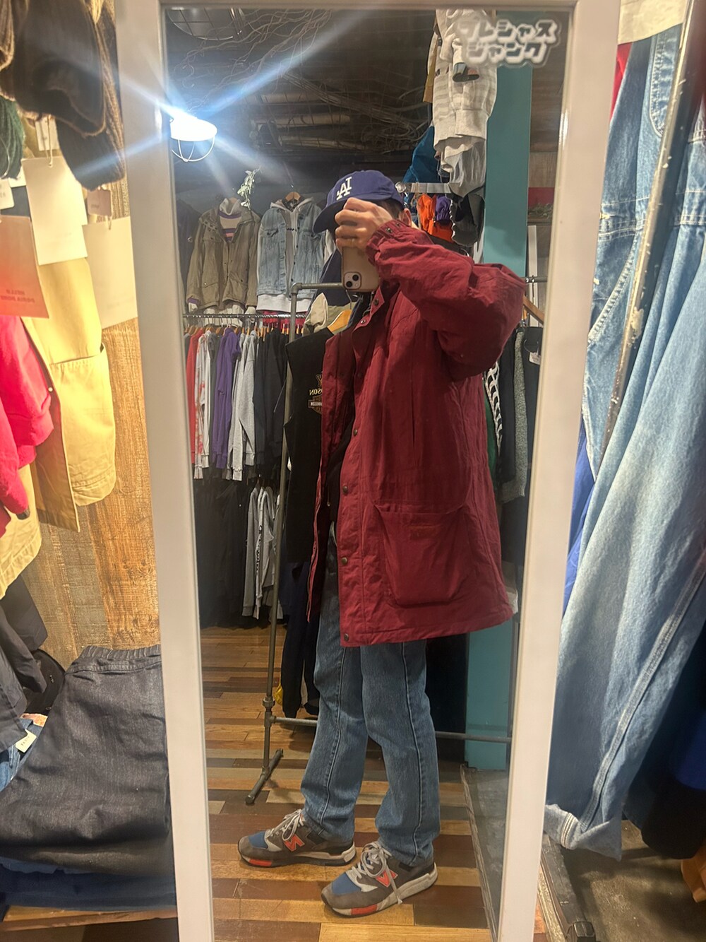 ブルー系のデニムパンツ、グレー系のスニーカー、レッド系のジャケット/アウターを着用したメンズの冬コーディネートの2枚目の写真